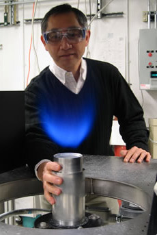 Роберт Чэн демонстрирует горелку своей системы. Он держит руку на корпусе, показывая, что стабильное пламя располагается полностью вне устройства, которое остаётся холодным (фото с сайта lbl.gov).