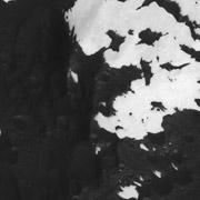 На этом кадре переходной зоны преобладает тёмный покров Япета, но его постепенно вытесняет белое снежно-ледяное покрытие, которое... (фото NASA/JPL/Space Science Institute).