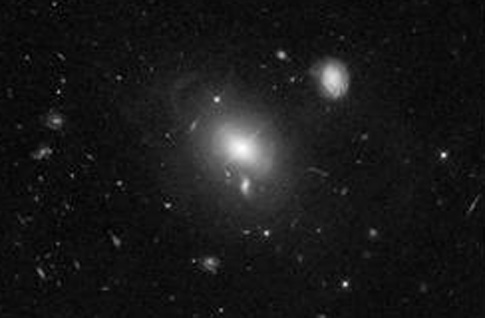 В центре снимка гигантская эллиптическая галактика на расстоянии 2 млрд. световых лет от нас. На фотографии можно различить внешние звездные кольца.