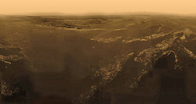Панорама, составленная из снимков, сделанных во время снижения зонда в атмосфере Титана. Цвета добавлены к этому чёрно-белому изображению на основе палитры цветного кадра с места посадки (фото с сайта web.mit.edu).